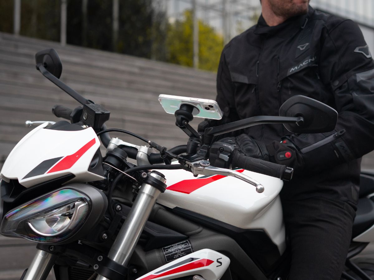 Un motard sur la route regardant son rétroviseur pour anticiper la circulation autour de lui. Une scène qui reflète l'importance d’une vigilance constante en milieu urbain.