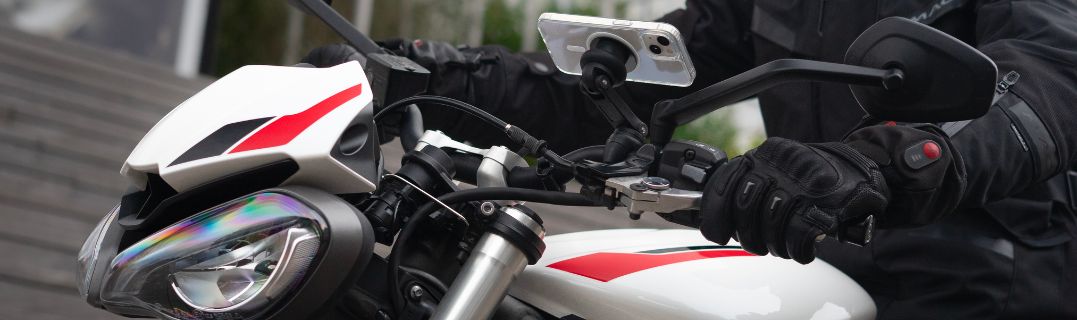 Un motard circulant en ville entre les voitures, illustrant les défis du trafic urbain. L’image montre l’importance de bien anticiper les mouvements des autres usag