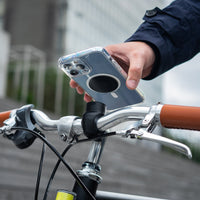 Smartphone équipé d'une plaque métal Shapeheart, fixation clap sur un guidon de vélo urbain.